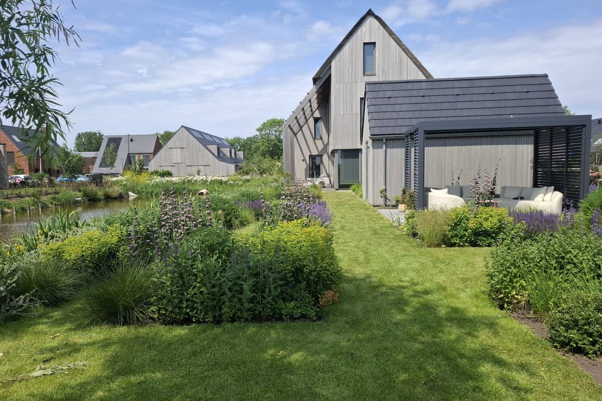 Woning met aluminium overkapping en zithoek in het groen